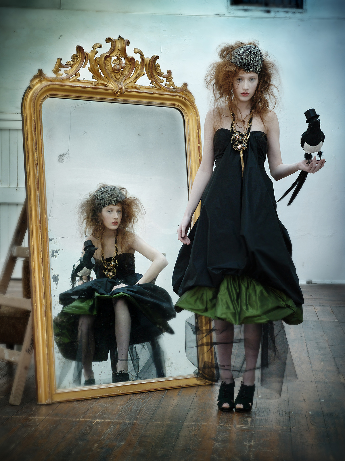 fashion editorial studio shoot of a redhead female , model in front of the mirror with vintagge props wearing contemporary irish design